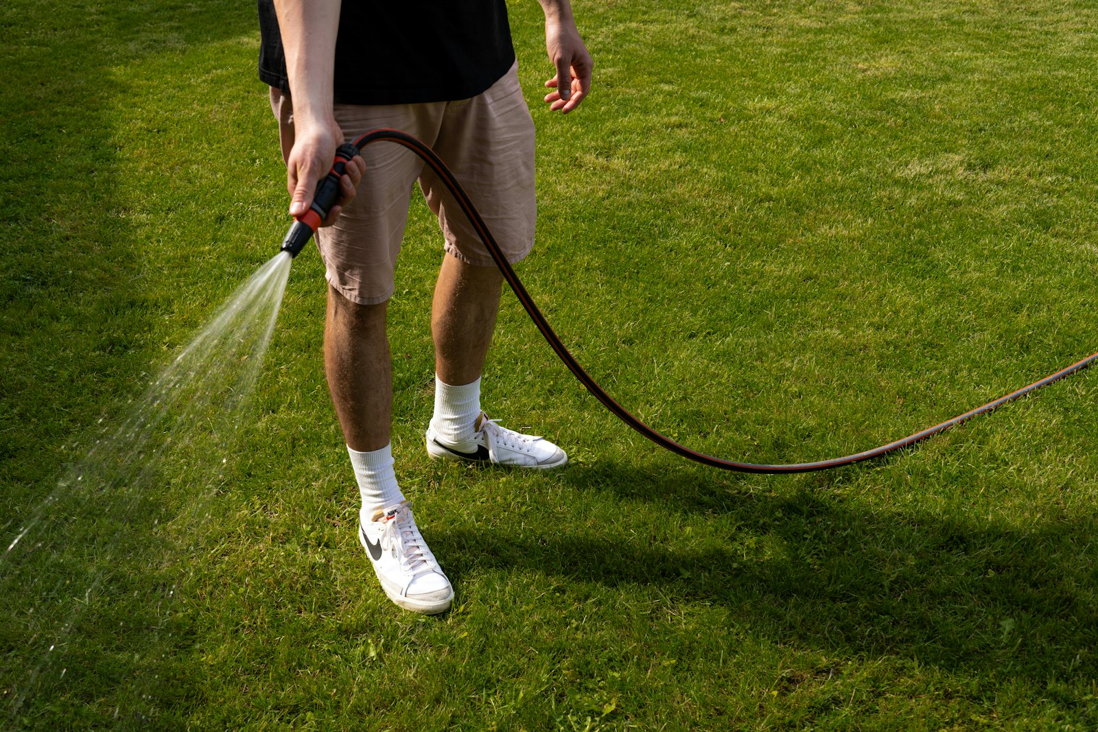 Worker spraying water on a freshly cleaned lawn